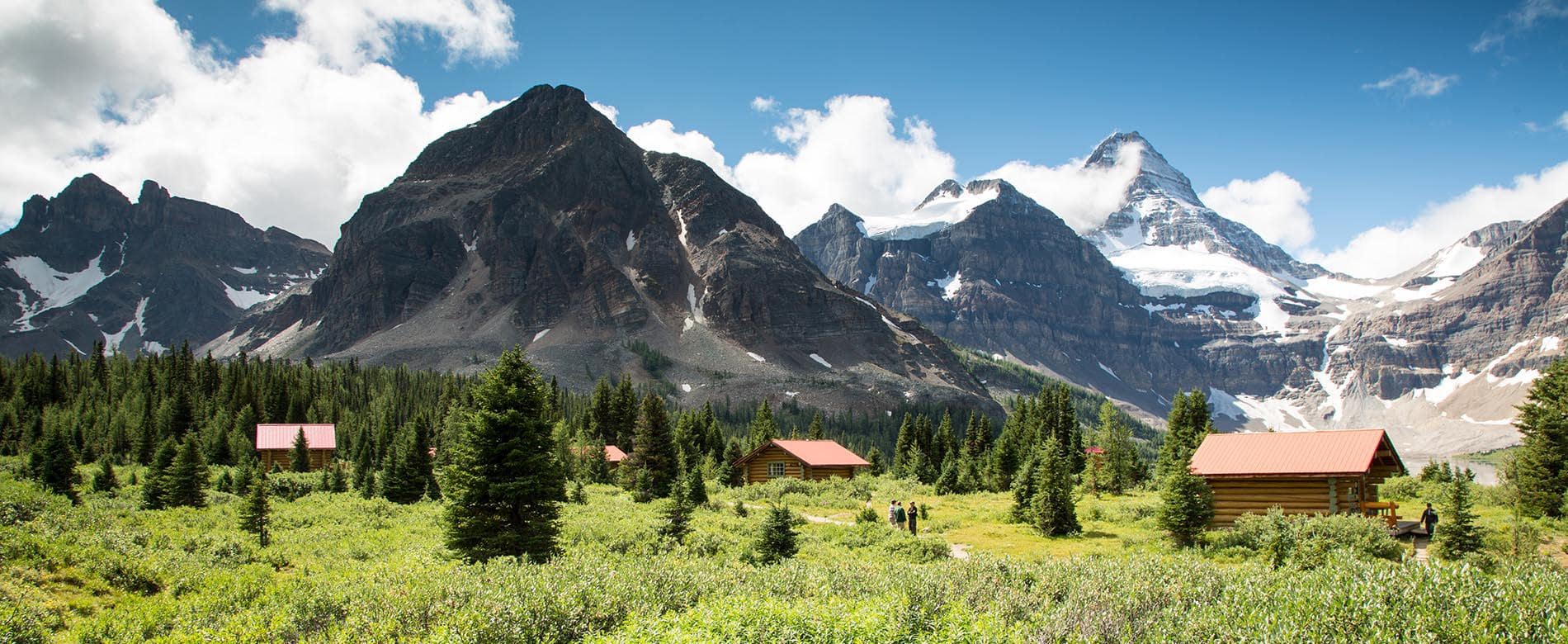 Lodge cabins nestled by Lake Magog with Mount Assiniboine backdrop