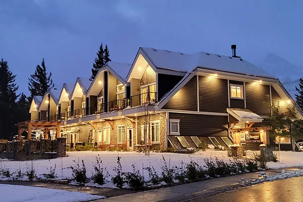 Kilmorey Lodge's lit contemporary exterior with peaked gables overlooks snowy grounds at dusk.