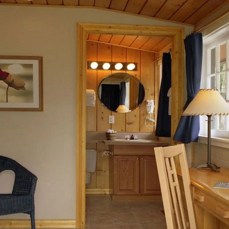 Overlander Lodge heritage cabin interior with natural wood vanity and round mirror with lights.