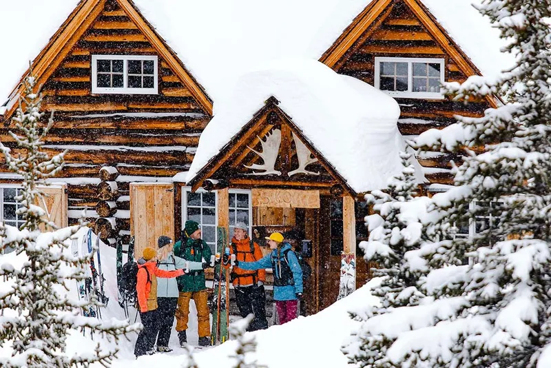 Skiers arriving at snow-covered lodge entrance in winter